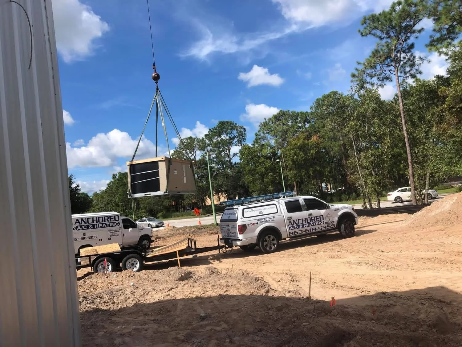 Anchored A/C & Heating crew craning a commercial rooftop HVAC unit into place in Polk County FL