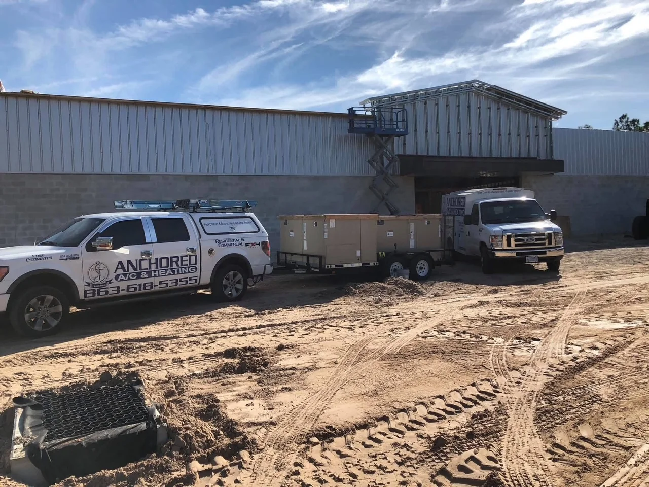 Anchored A/C & Heating branded service trucks and van at a Polk County FL job site